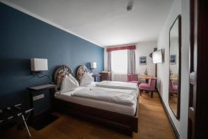 萨尔茨堡施塔特克鲁格老城区酒店的一间卧室设有一张床和蓝色的墙壁