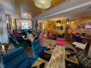 阿尔滕堡Boutiquehotel Mason的一间餐厅,房间内设有五颜六色的椅子和桌子