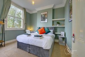 利明顿温泉Leamington Spa Warwick Place Apartments的一间卧室配有一张带色彩缤纷枕头的大床