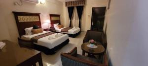吉布提Ras Dika Hotel的酒店客房设有两张床和一张桌子。