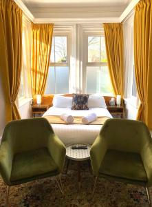阿什比德拉祖什The Cedars Ashby的一间卧室配有一张床和两张绿色椅子