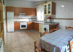 莫利纳塞卡Casa Rural Elias的厨房配有桌子、冰箱和炉灶。
