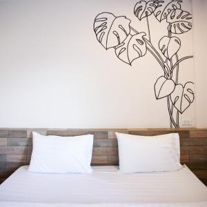 Ban Komo Sip PaetTree Home ที่พักเบตงสไตล์ครอบครัว的卧室配有一张挂着花纹的床