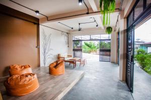 Ban Komo Sip PaetTree Home ที่พักเบตงสไตล์ครอบครัว的客厅配有橙色椅子和桌子