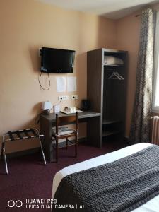 普瓦捷孟菲斯酒店的酒店客房设有一张床、一张书桌和一台电视机。