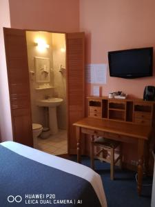 普瓦捷孟菲斯酒店的客房设有书桌和带电视的浴室。