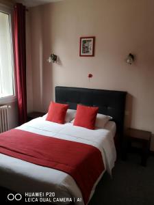 普瓦捷孟菲斯酒店的一间卧室配有一张带红色枕头的大床