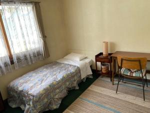 白马村风白马旅馆的一间卧室配有一张床、一张桌子和一张桌子