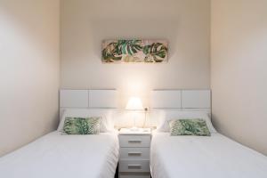 塞维利亚Lumbreras Host的白色墙壁客房中的两张单人床