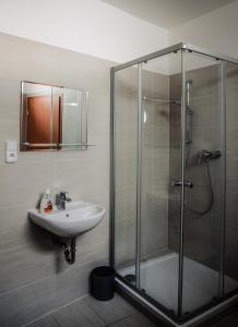 奥洛穆茨乌贾库巴酒店的一间带玻璃淋浴和水槽的浴室