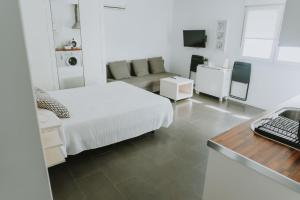 萨阿拉德洛斯阿图内斯Apartamentos ZHR 2的白色卧室配有床和书桌