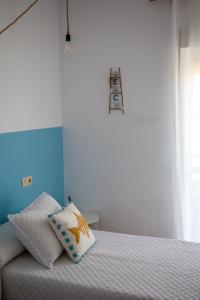 莫哈卡尔H El Palmeral Playa的一间卧室配有一张带枕头的床
