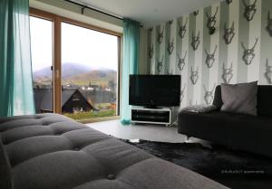 黑林山区贝尔瑙Haus Weitblick - Fewo Herzogenhorn - Bernau, Schwarzwald的带沙发和平面电视的客厅