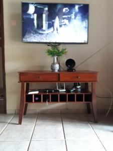 沙帕达-杜斯吉马朗伊斯Casa das Flores的木桌,墙上配有电视