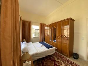 纳布卢斯Hayat Guest House的一间卧室配有一张床和一个木制橱柜