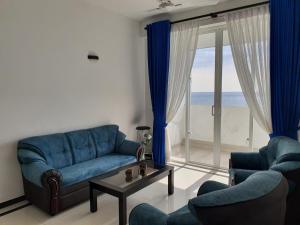 代希瓦勒New 2 bedroom apartment, 100m away from the beach的客厅配有蓝色的沙发、椅子和窗户