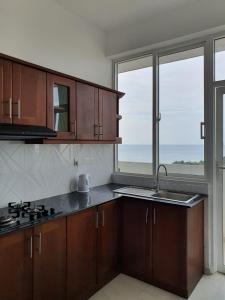 代希瓦勒New 2 bedroom apartment, 100m away from the beach的一个带木制橱柜和大窗户的厨房