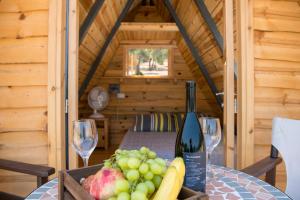 尼奥克瑞奥Aphrodite Family Eco Camping的一张木桌,上面放着一瓶葡萄酒和葡萄