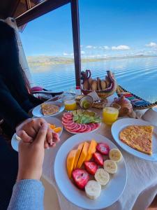 普诺Luz del Titicaca Lodge的一张桌子,上面放着盘子,享有水景