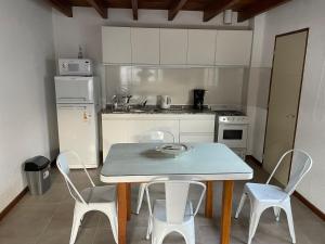 图努扬Valle de Uco. Departamento 2 habitaciones 4 huéspedes.的厨房配有桌椅和冰箱。