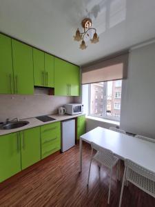 陶格夫匹尔斯Central station的厨房配有绿色橱柜和白色桌子