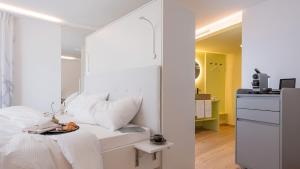 菲茨瑙Neuro Campus Hotel的卧室配有一张带镜子的白色床