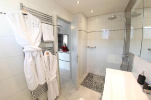 塞莱斯塔La Maison de Jeanne的带淋浴的浴室和架子上的白色毛巾
