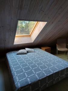 JõgelaRatsu Turismitalu的阁楼上的卧室设有一张床,设有窗户