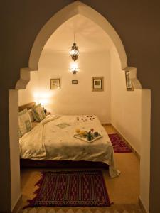 马拉喀什谢里哈尼摩洛哥传统庭院住宅的一间卧室,配有拱形床