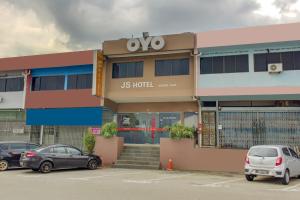 新山Super OYO 89985 Js Hotel的一家酒店,停车场内有车辆停放