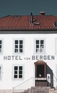 La SagneHôtel Von Bergen的白色的建筑,上面有读酒店面包车的标志