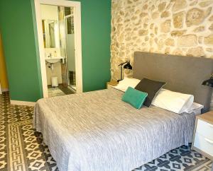 阿利坎特Pensión Alicante San Nicolás的一间卧室配有一张带绿色墙壁的床