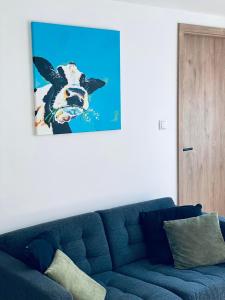 胡法利兹Little Marguerite的客厅里一张蓝色的沙发,上面有一副牛的画