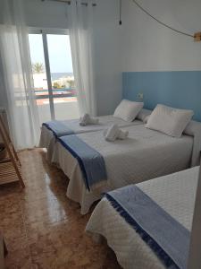 莫哈卡尔H El Palmeral Playa的海景卧室内的两张床