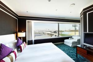 东京东京繁花青山酒店的一间酒店客房,设有一张大床和一个大窗户