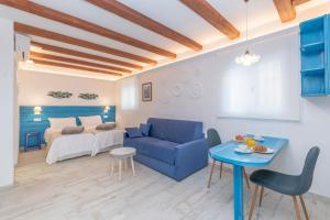 EsteponaCASA AZUL - Boutique Apartments by Casa del Patio的客厅配有蓝色的沙发和床。