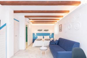 EsteponaCASA AZUL - Boutique Apartments by Casa del Patio的客厅配有蓝色的沙发和床。