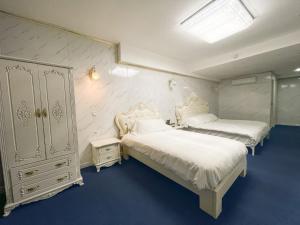 马尼塞斯Hotel Aviación的配有白色家具的客房内的两张床