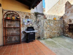 ManjirónCasa rural en la Sierra Norte de Madrid的厨房配有炉灶和石墙