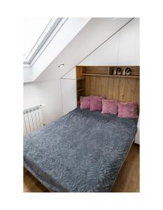 戈乌达普Apartament Kornelia的一间卧室配有一张带紫色枕头的大床