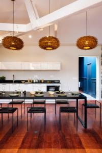 波尔多Volubilis Luxury Guest House的厨房配有大型黑桌和椅子