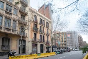 巴塞罗那巴塞罗那埃克萨潘区公寓的一条拥有高楼和黄色围栏的城市街道