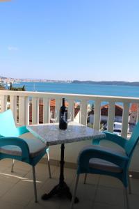 特罗吉尔Apartments Renata的阳台上的桌子和一瓶葡萄酒