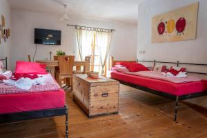 克拉尼斯卡戈拉Country House Trata的一间卧室配有两张带红色床单和桌子的床