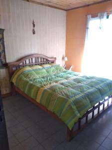 波特雷里约斯El sueño del Nono的一间卧室配有一张带绿色和黄色棉被的床