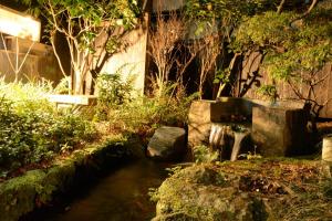 三岛市Guesthouse giwa - Vacation STAY 14271v的花园,有溪流和树木