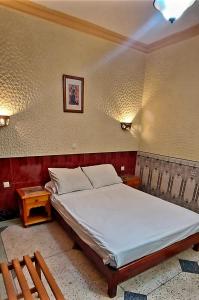 胡塞马Hôtel National的一间卧室配有一张大床和两张桌子