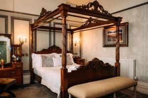 莱瑟姆-圣安妮The Queens Hotel的一间卧室设有四柱天蓬床