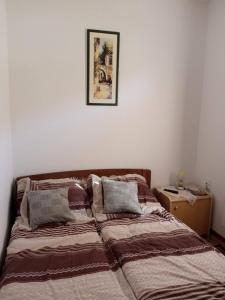 KalnaKuća Talija的卧室内的一张床铺,墙上挂着一幅画