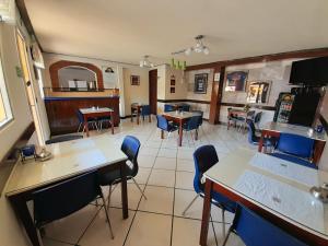 克萨尔特南戈Hotel y Restaurante Villa Esmeralda的一间在房间内配有桌椅的餐厅